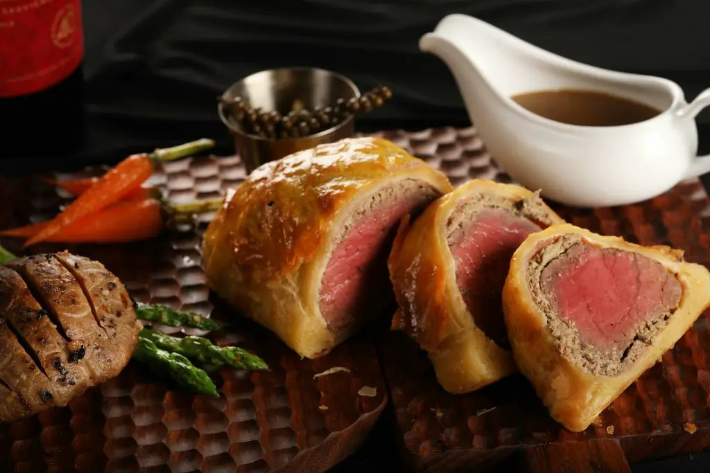 How do you keep the bottom crust from getting soggy in Beef Wellington?